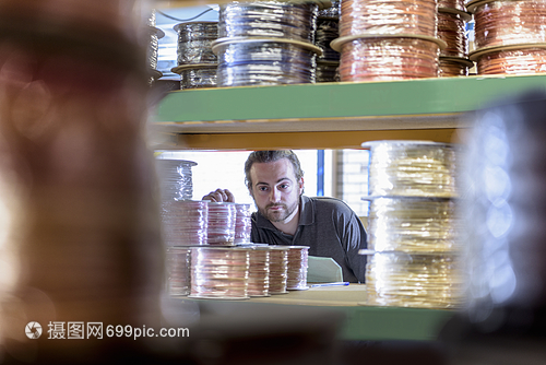 在電纜工廠從貨架上選擇產品的工人